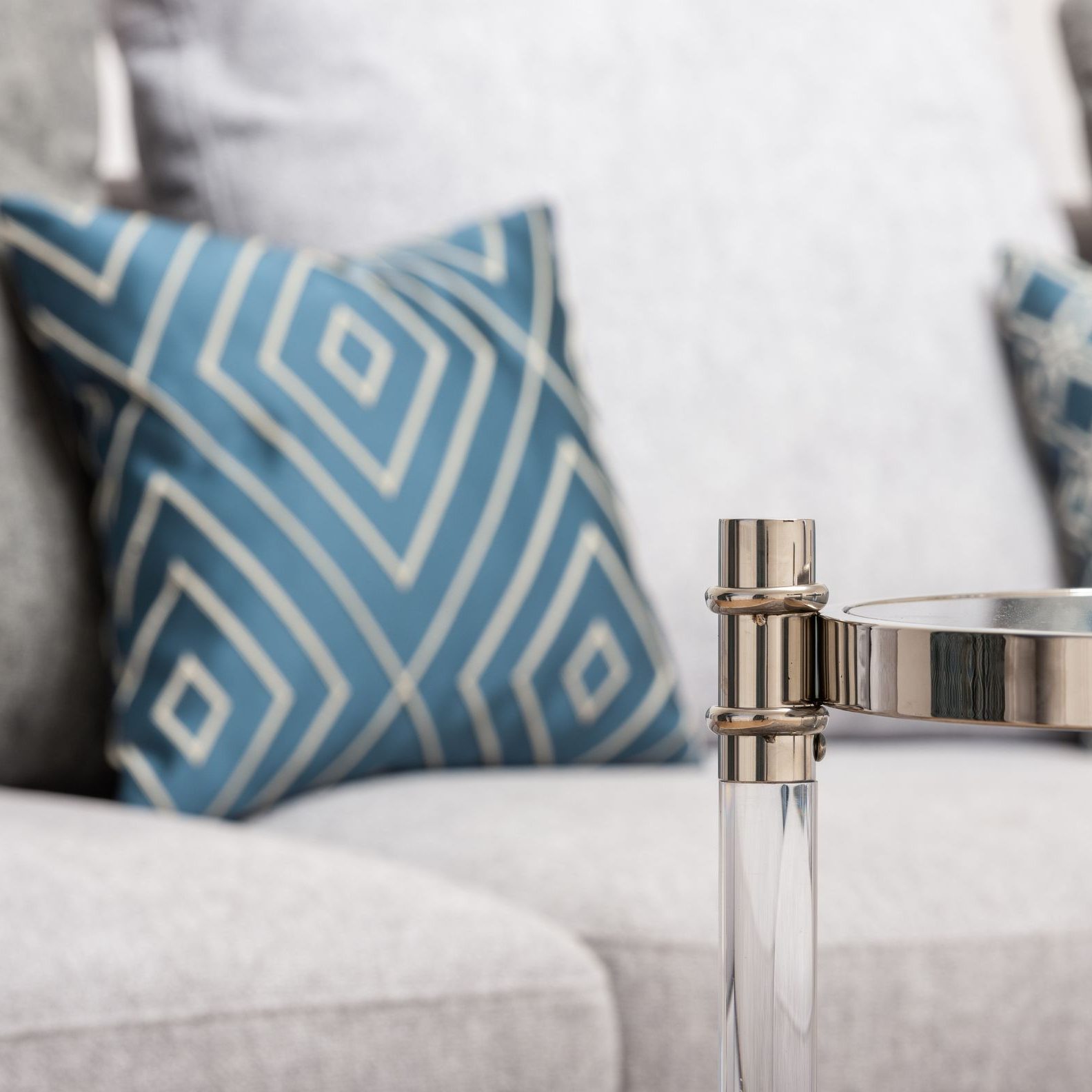 A woven cushion in blue and white geometric pattern on a sofa