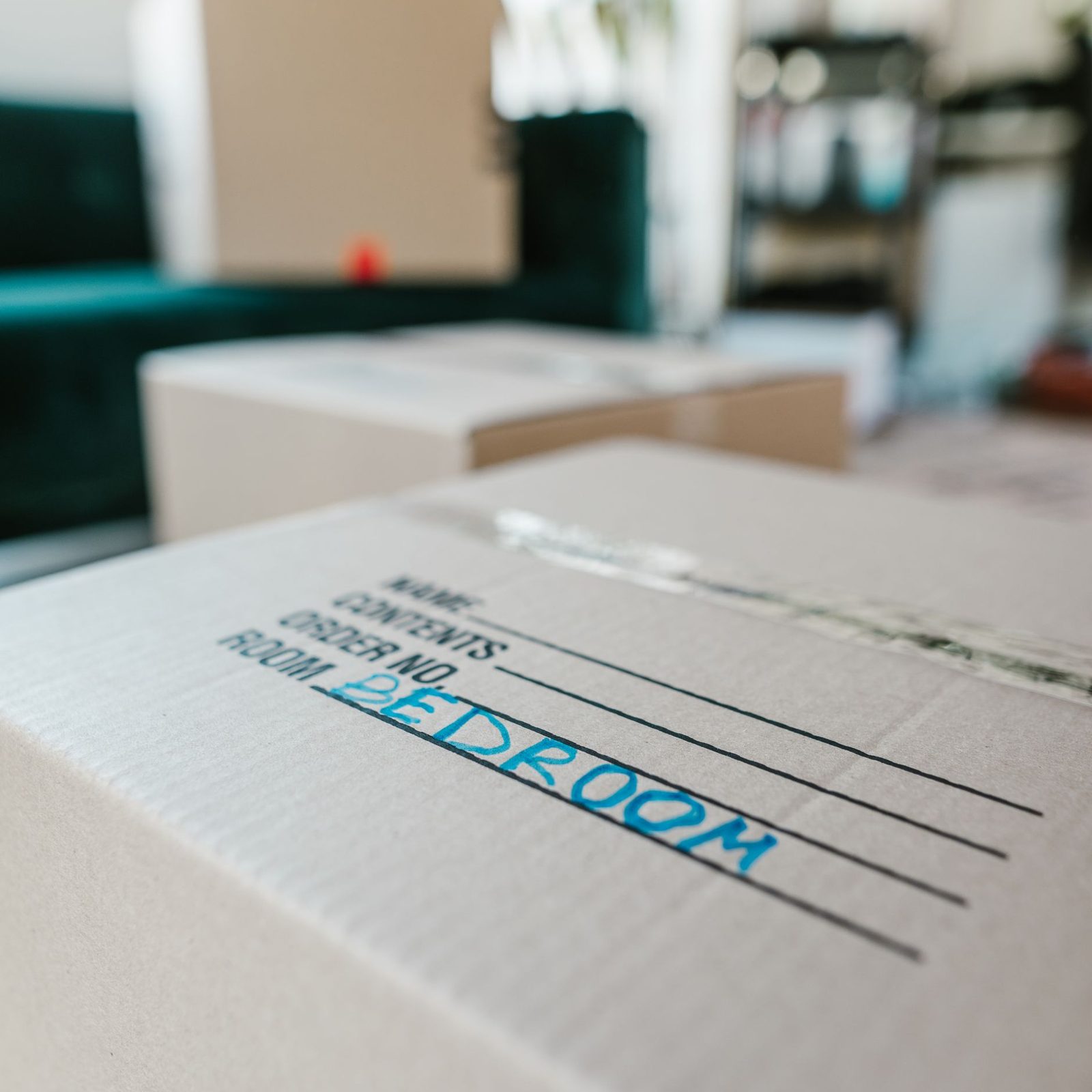 A cardboard moving box labelled by room in marker pen