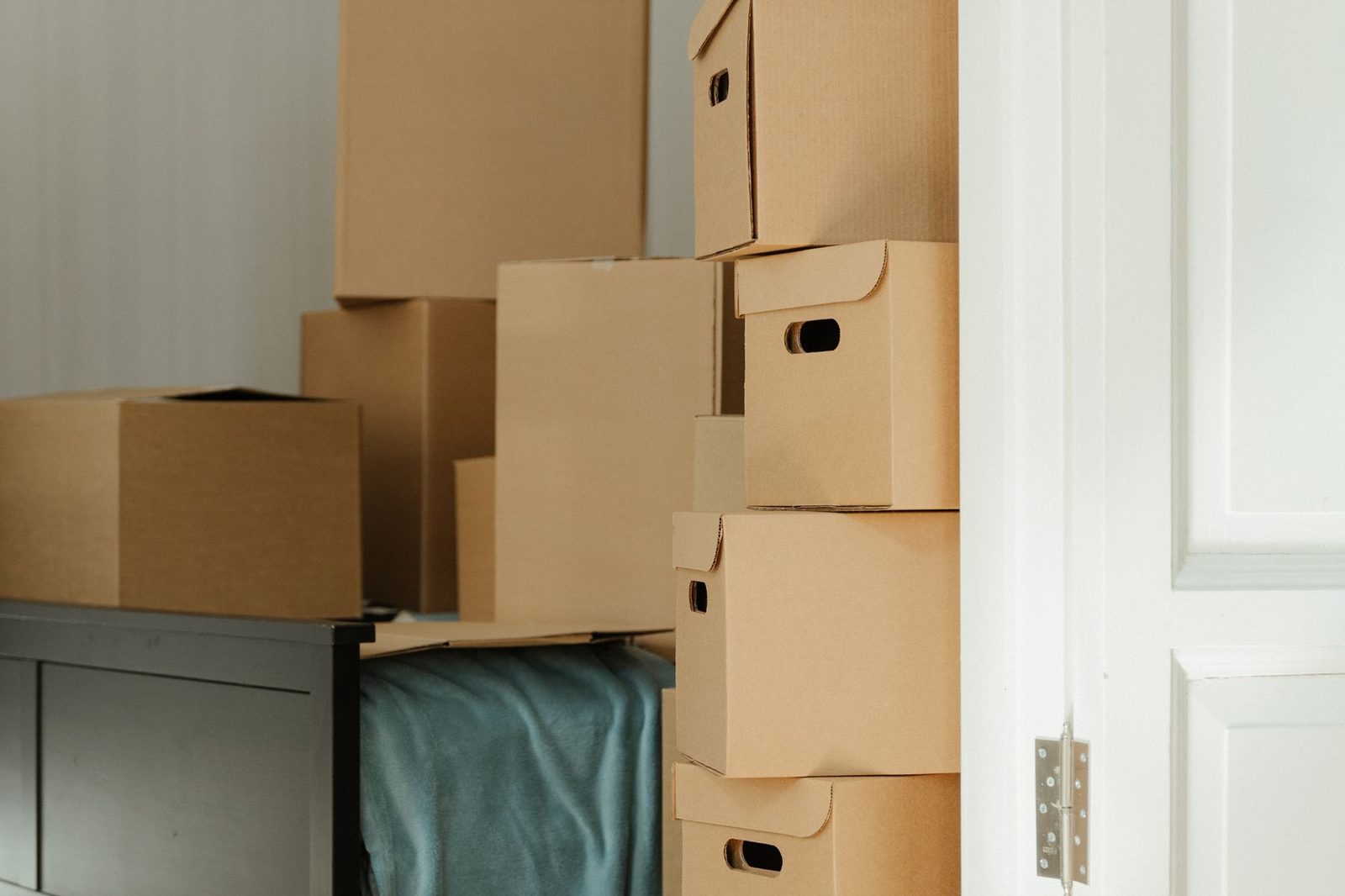 A stack of sealed cardboard moving boxes in an empty room