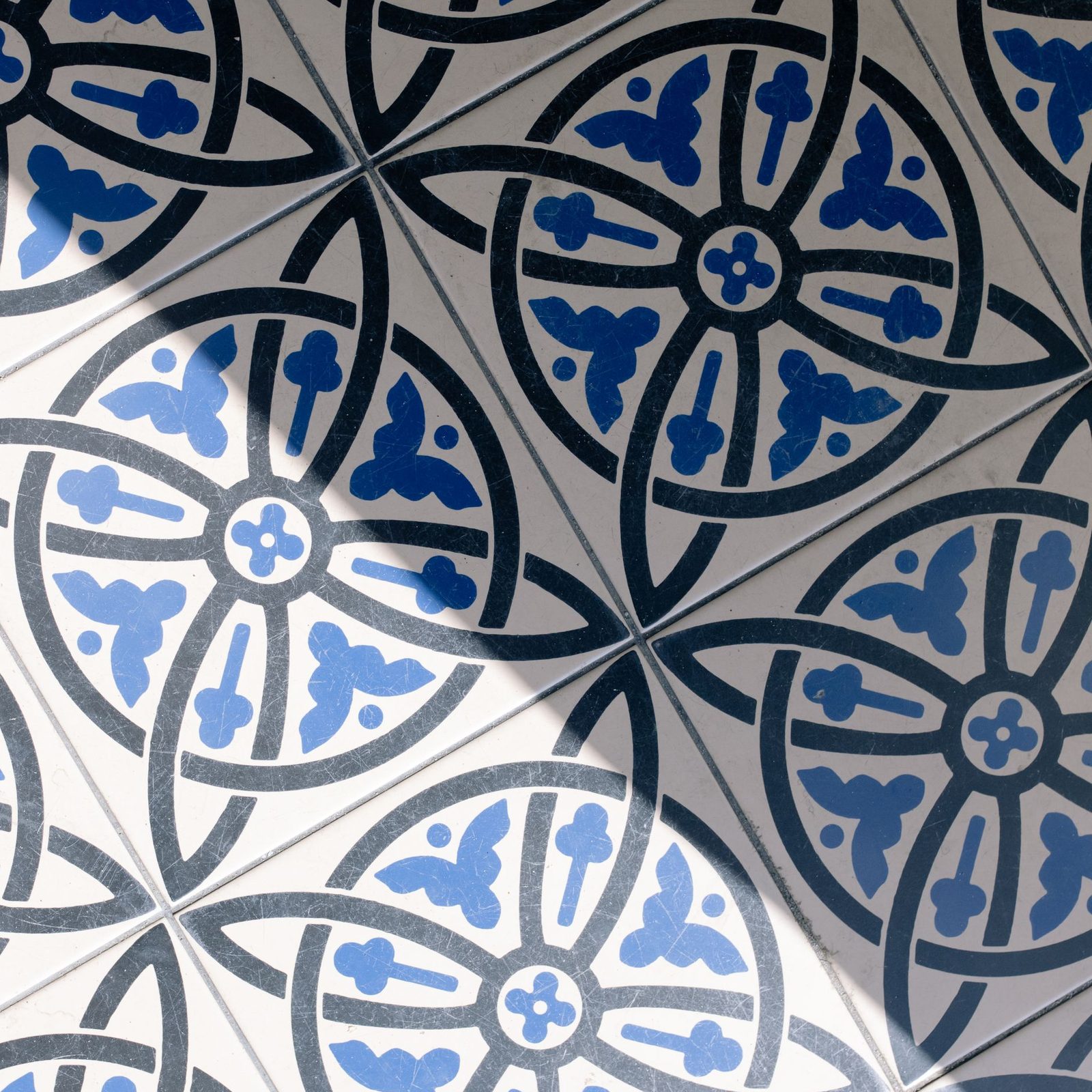 Blue and white ceramic tiles laid so their quarter-circle arcs join into continuous curves