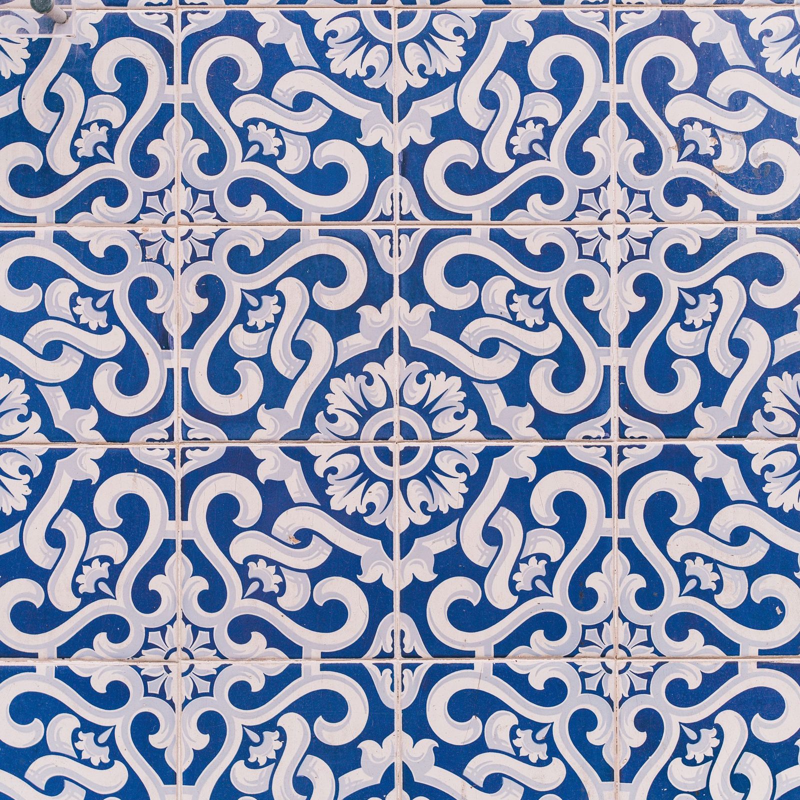 A wall of blue and white Portuguese azulejo tiles in a repeating floral pattern