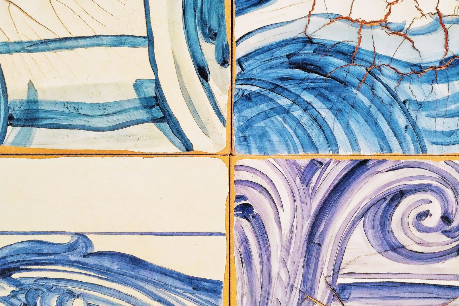 A close view of hand-painted blue brushwork on white glazed tile